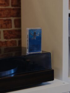 Nirvana Nevermind cassette case placed on a retro turntable in a cozy room setting