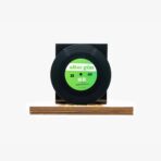 Black vinyl record displayed on a wooden stand with a bright green label that reads 'altun gün'