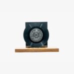 Black vinyl record mounted on a wooden display base against a white background, centered in the image.