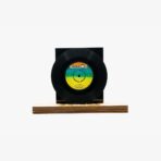 Decorative black vinyl record mounted on a wooden block display against a white background.