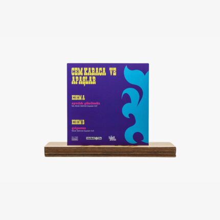 Album cover for Cem Karaca ve Apaşlar on a purple background with bold yellow title and blue abstract shapes, shown on a wooden display stand.