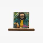 Vintage vinyl album cover for Cem Karaca featuring a man with dark glasses, beard, and long hair in a yellow turtleneck and teal jacket, pink 'Cem Karaca' text, on a wooden stand.