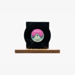 Black vinyl record mounted on a wooden base with a pink and teal label that reads 'türkofon' in the center.