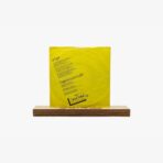 Bright yellow poster with black text standing on a small wooden display base.