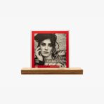 Album cover for Zalim by Ceylan Ertem: black-and-white portrait of a woman with hand to her face, red border, on a wooden shelf.