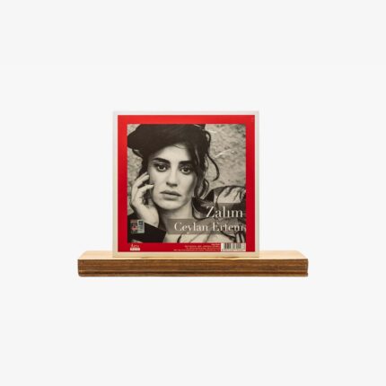 Album cover for Zalim by Ceylan Ertem: black-and-white portrait of a woman with hand to her face, red border, on a wooden shelf.