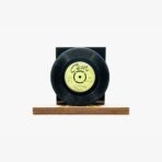 Decorative vinyl record mounted on a wooden base with a black backing display piece.