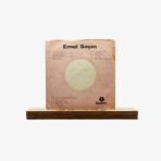 Vinyl record sleeve for Emel Sayin on a wooden display stand, pink cover with a large circular cutout and Balet logo in the corner, text visible on the front