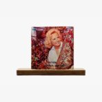 Vintage vinyl album cover: smiling blonde woman in a patterned shawl, with red autumn leaves in the background on a wooden stand.