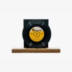 Black vinyl record mounted on a wooden base with a black backing, featuring a yellow SOYAN label at the center.