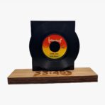Decorative vinyl record on a wooden base with a stamped number, displayed upright against a neutral background.
